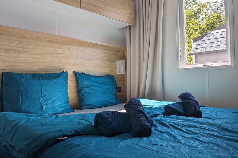 Ein komfortables Zimmer mit Holzboden und gemütlichem Bett.