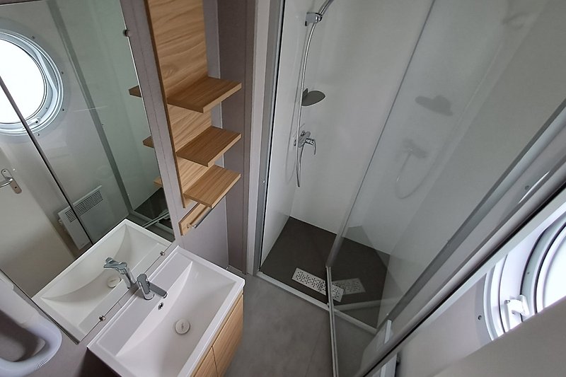 Moderne Badezimmerausstattung mit Spiegel und Waschbecken.