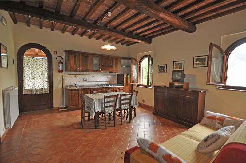 Un accogliente soggiorno con angolo cottura con mobili in legno e design d'interni rustico toscano (tri locale 6)
