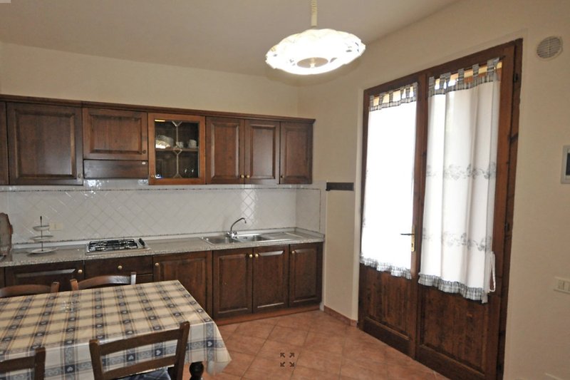 Una cucina moderna con un lavello in legno e una finestra luminosa (soggiorno app bilocale 2)