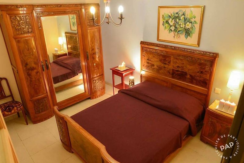 Détendez-vous dans cette chambre confortable avec un lit en bois et une décoration chaleureuse. Profitez de la lampe pour lire un livre avant de vous endormir.