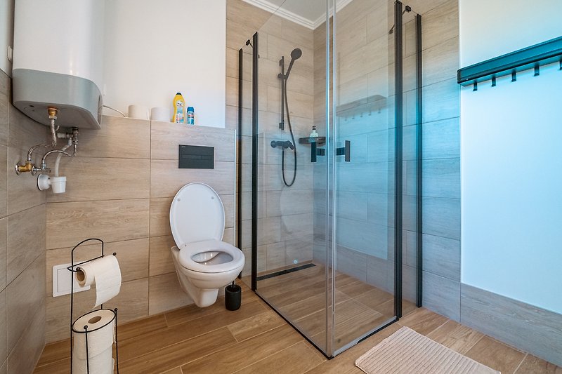 Genießen Sie eine luxuriöse Dusche in diesem modernen Badezimmer. Entspannen Sie sich und fühlen Sie sich wie zu Hause.