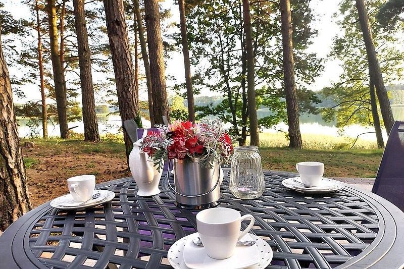 Ein idyllischer Platz zum Frühstücken im Freien mit Blick auf den See und die Landschaft.