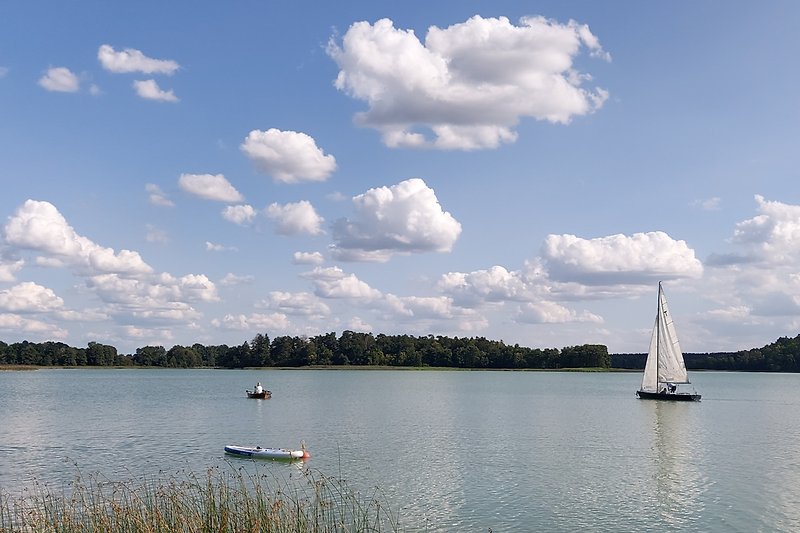 Wunderschöner See mit Booten und blauem Himmel. Perfekt für Wassersport und Erholung.