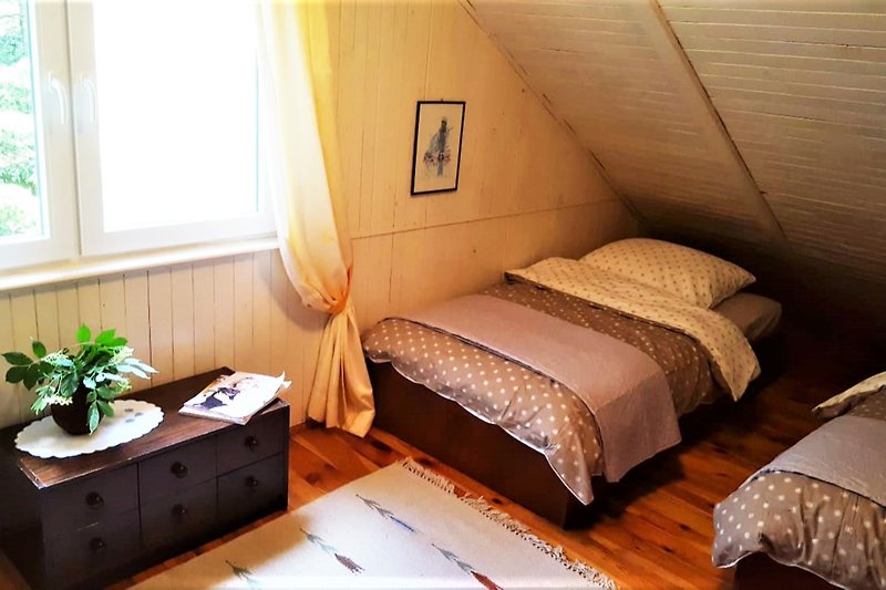 Gemütliches Schlafzimmer mit stilvollem Holzmöbel und bequemen Betten. Perfekt zum Entspannen.