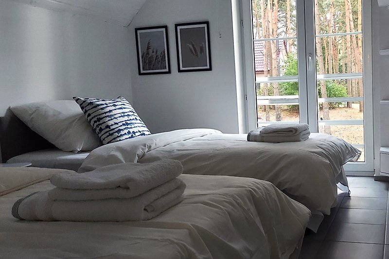 Gemütliches Schlafzimmer mit bequemen Betten und schönem Seeblick.