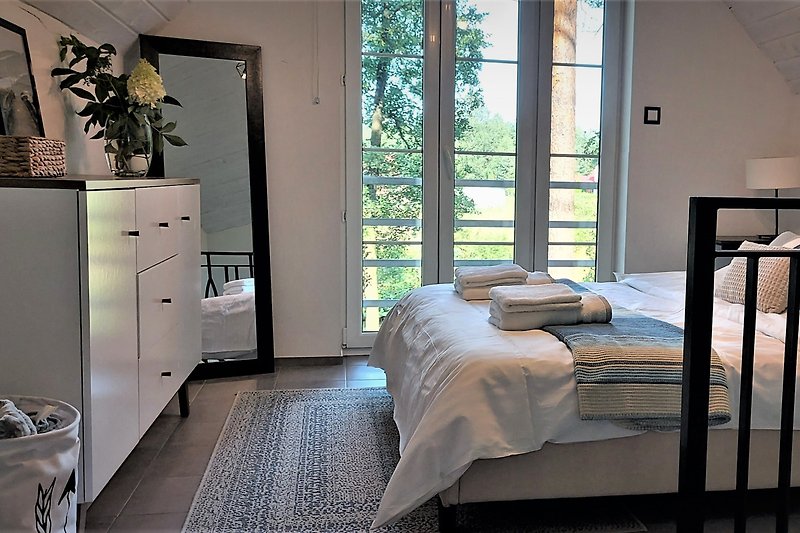 Gemütliches Schlafzimmer mit Holzmöbeln und Seeblick.