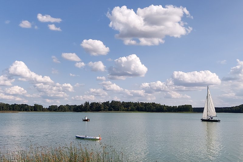 Wunderschöner See mit Booten und blauem Himmel
