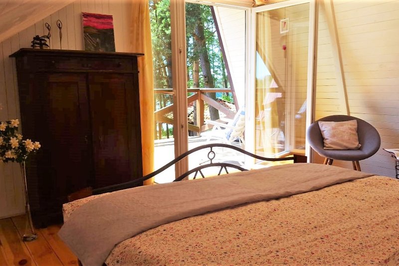 Gemütliches Schlafzimmer mit  komfortablem Bett und grossem Balkon mit Seeblick. Dort der erster Kaffee schmeckt perfekt