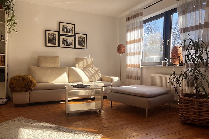 Stilvolles Wohnzimmer mit Holzboden, gemütlicher Couch im unteren Wohnbereich
