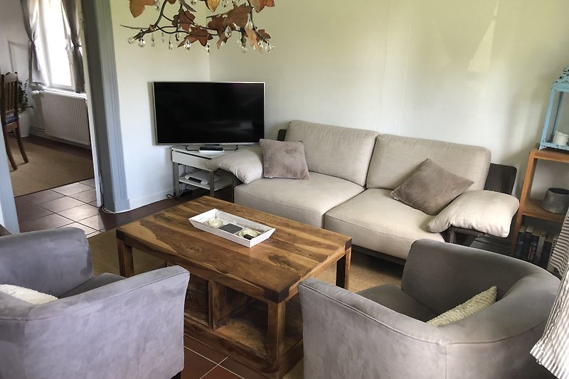 Gemütliches Wohnzimmer mit  bequemer Couch und Fernseher.
