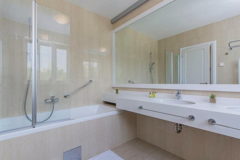 Schönes Badezimmer mit Spiegel, Waschbecken und Badewanne.