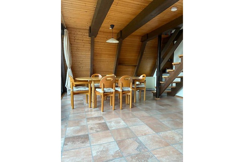Schönes Interieur mit Holzboden, Stühlen und Vorhängen.