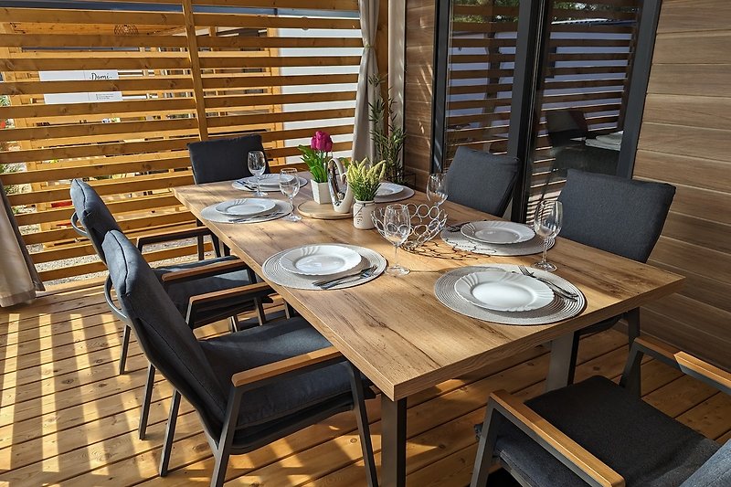 Bequemer Esstisch mit Sitzgelegenheiten, der den idealen Rahmen für gemeinsame Mahlzeiten im Freien schafft.