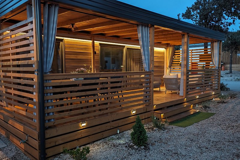 Rustikales Holzhaus mit grünem Gartenblick und gemütlicher Veranda.