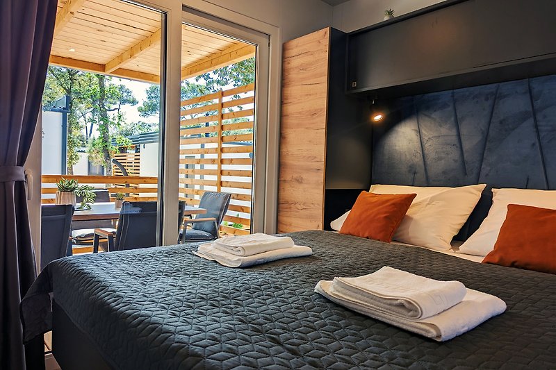 Das Schlafzimmer lädt die Natur ein und bietet einen gemütlichen Rückzugsort mit bequemer Bettwäsche.