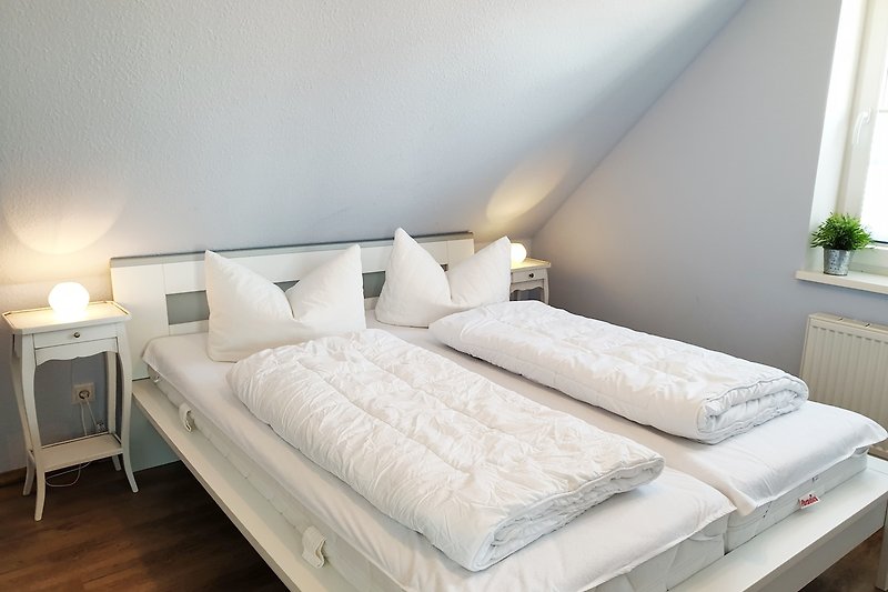 2. Doppelbettschlafzimer mit gemütlichem Bett, stilvoller Lampe und Fensterblick.