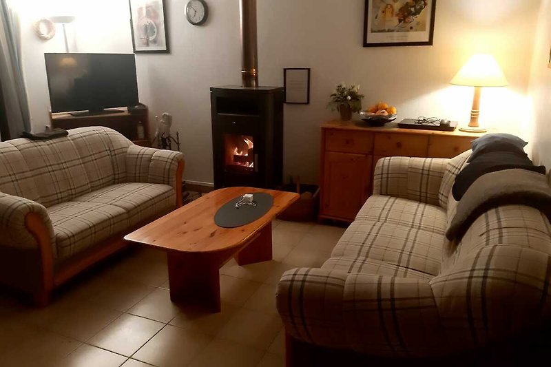 Gemütliches Wohnzimmer mit bequemen Möbeln, Holzboden und stilvoller Beleuchtung.