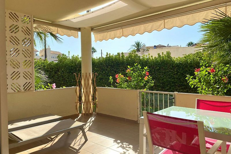 Geräumige Terrasse mit Pergola und Gartenmöbeln, umgeben von Natur.