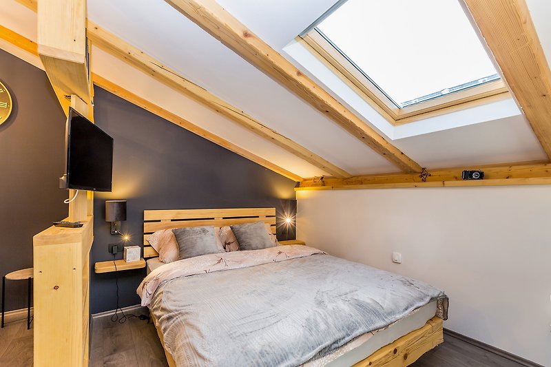 Udobna spavaća soba s drvenim namještajem i žutim detaljima.