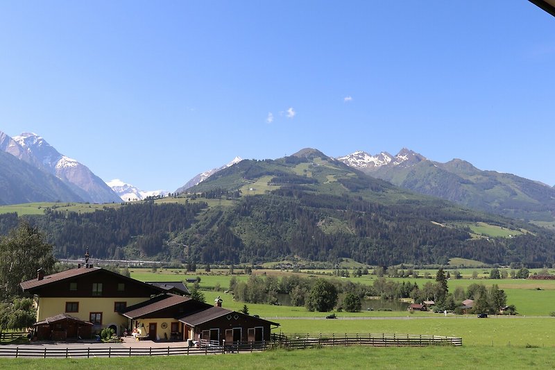 Blick durch Wohnzimmerfenster auf das Hochgebirgs-Ski und Wandergebiet Maiskogel und den Gletscher Kitzsteinhorn