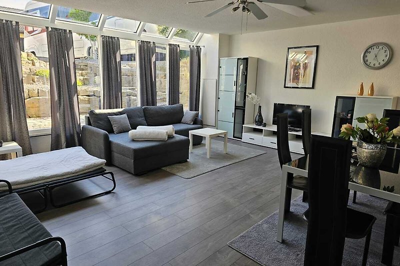 Willkommen in diesem stilvollen Wohnzimmer mit bequemen Möbeln und moderner Inneneinrichtung. Entspannen Sie sich und genießen Sie den Komfort.