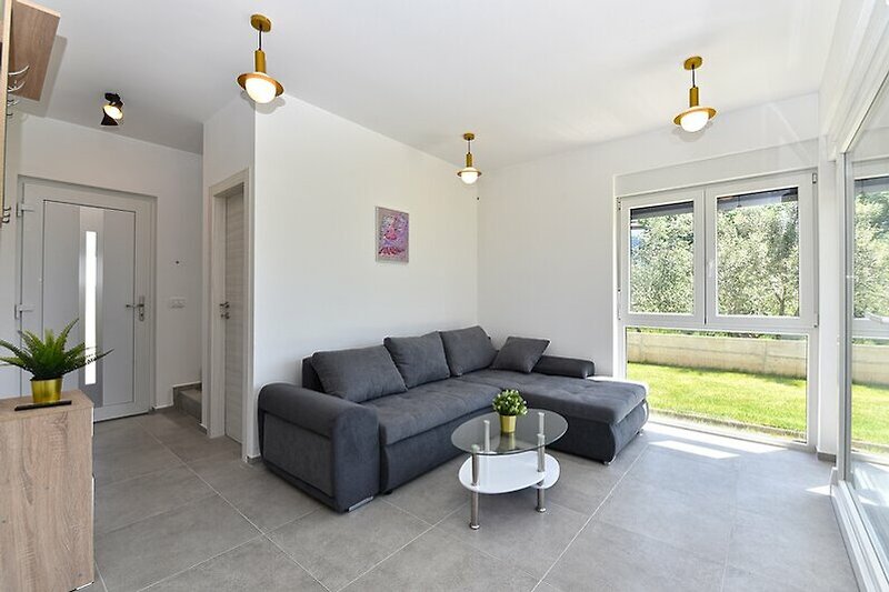 Modernes Wohnzimmer mit gelben Möbeln, Pflanzen und stilvoller Beleuchtung.