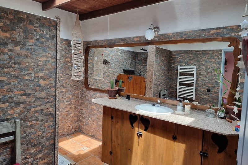 Schönes Badezimmer mit Holzwaschbecken und stilvoller Inneneinrichtung.