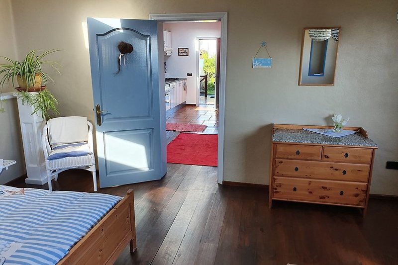 Gemütliches Schlafzimmer mit Holzmöbeln und blauem Bett.