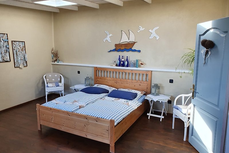 Gemütliches Schlafzimmer mit blauem Bett und Holzmöbeln.
