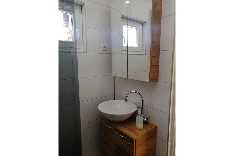 Schönes Badezimmer mit Spüle, Spiegel und Badezimmerschrank.