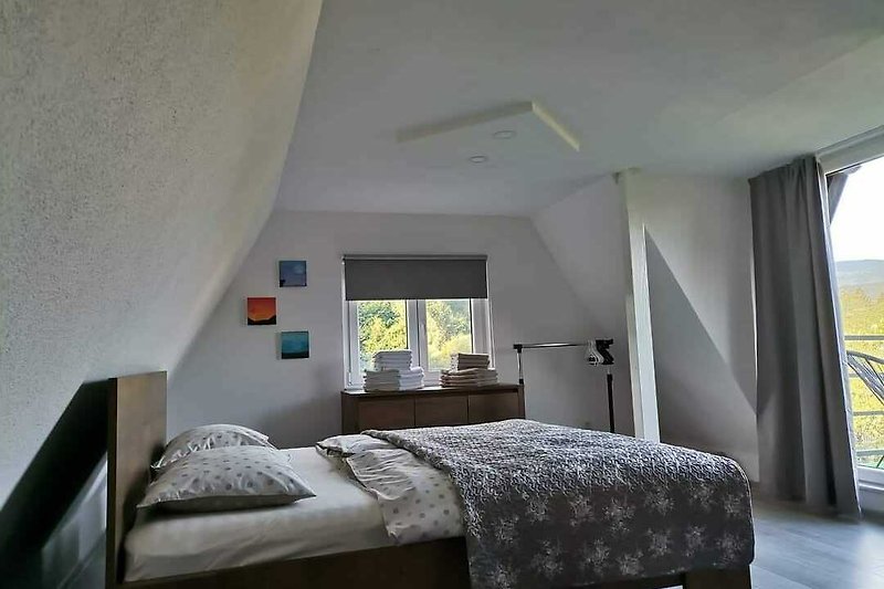 Gemütliches Schlafzimmer mit bequemem Holzbett und gemütlicher Beleuchtung. Perfekt zum Entspannen.