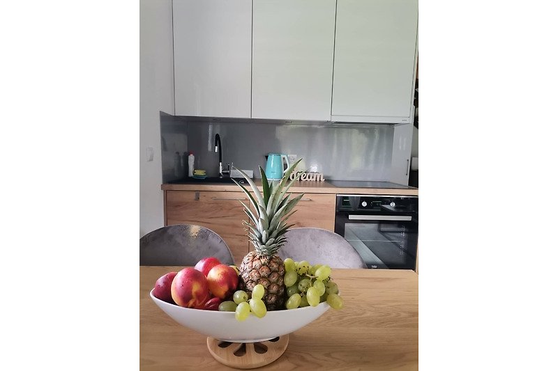 Gemütliche Küche mit Ananas, Obst und Küchengeräten. Perfekt für Ferien.