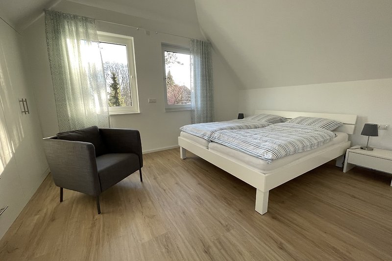 großes Schlafzimmer mit Doppelbett 180x200cm, großzügigem Einbauschrank und hoher Decke
