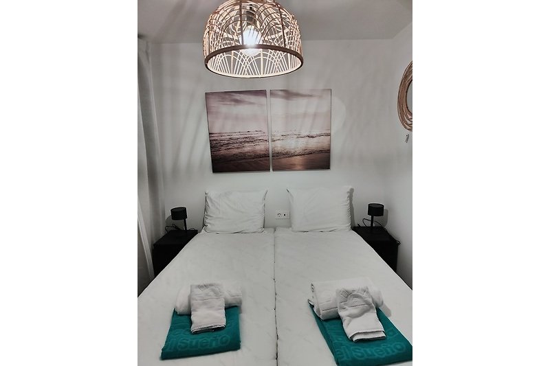 Comfortabele slaapkamer met houten bedframe en sfeervolle verlichting.