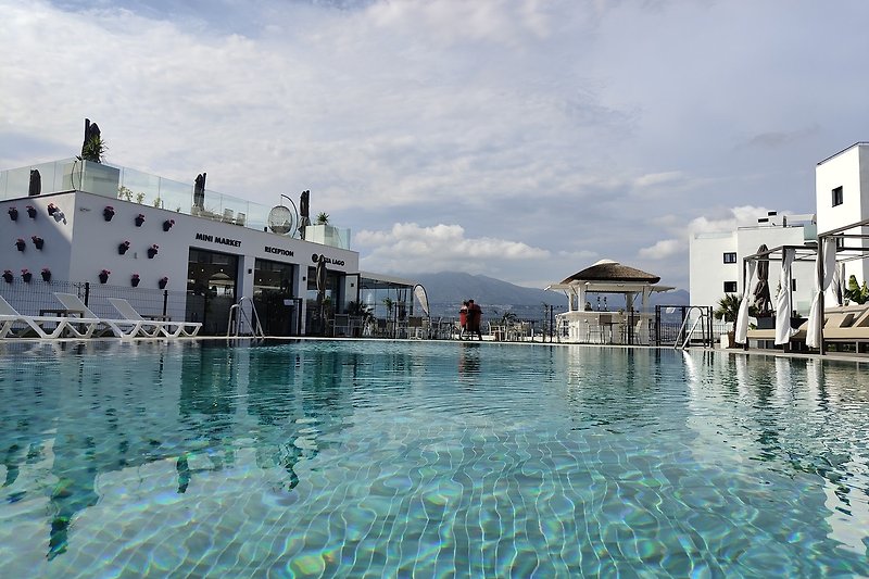 Het zwembad met zicht op restaurant Vista Lago en de receptie