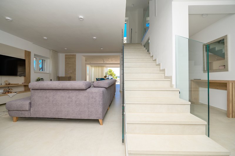 Elegante Treppe und elegantes Wohnzimmer mit Meerblick
