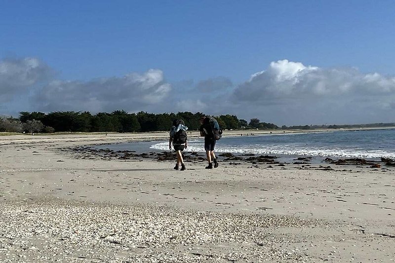 Randonneurs sur la grande plage de l'Ile-Tudy
