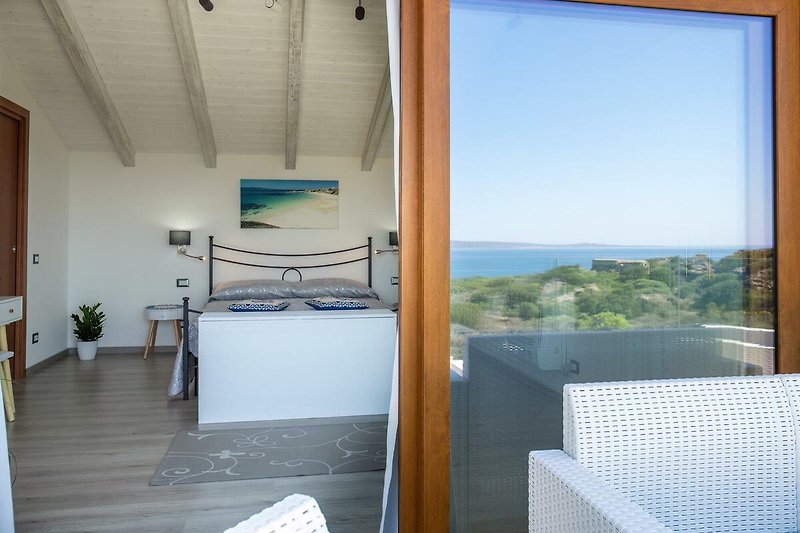 Una casa con ampie finestre, pavimento in legno e una vista panoramica sul mare. Goditi il comfort e la tranquillità.