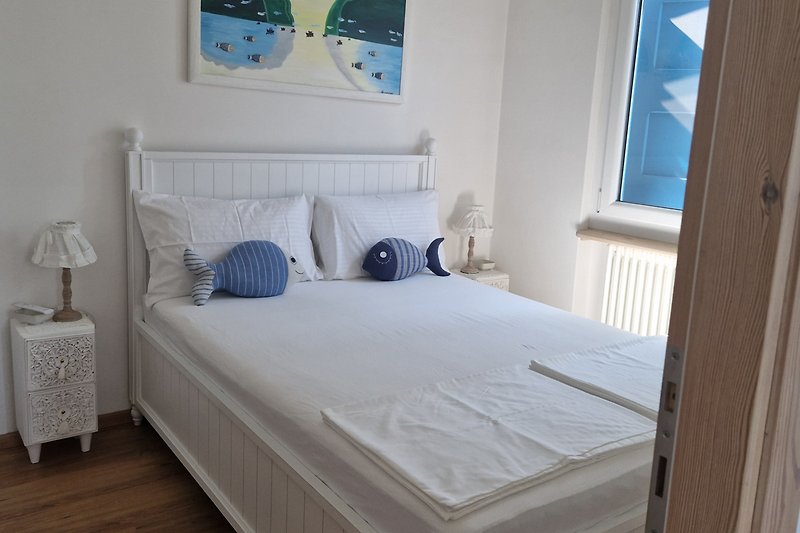 Goditi una vacanza rilassante in questa camera da letto confortevole con arredamento in legno e vista dalla finestra.