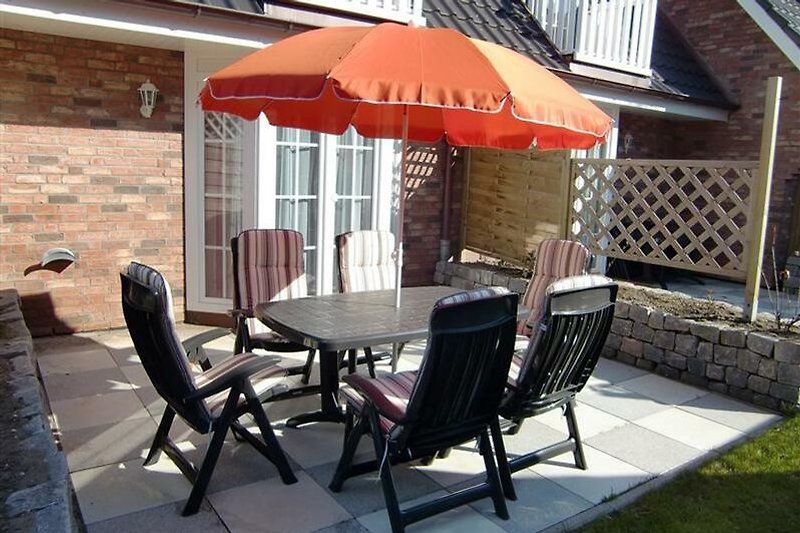 Schöne Outdoor-Möbel und Sonnenschirm. Perfekt zum Entspannen und Genießen der Natur.