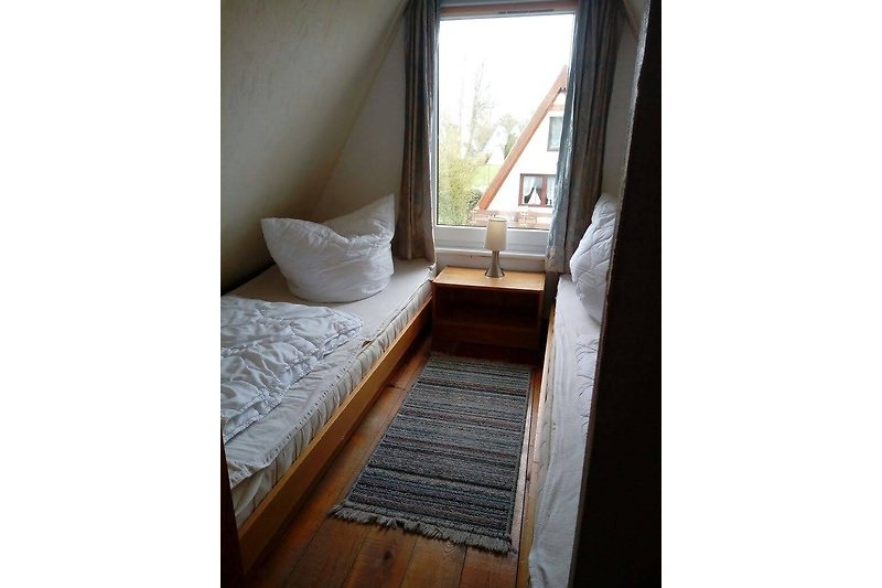 Gemütliches Schlafzimmer mit bequemem Bett und Fenster mit schöner Aussicht. Perfekt zum Entspannen und Ausruhen.