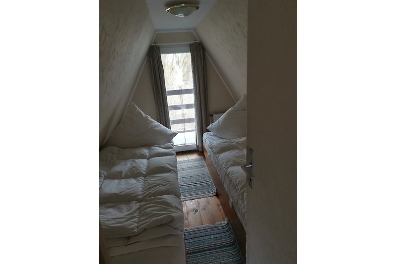 Gemütliches Schlafzimmer mit Holzmöbeln, bequemem Bett und Fenster mit schöner Aussicht. Perfekt zum Entspannen und Ausruhen.