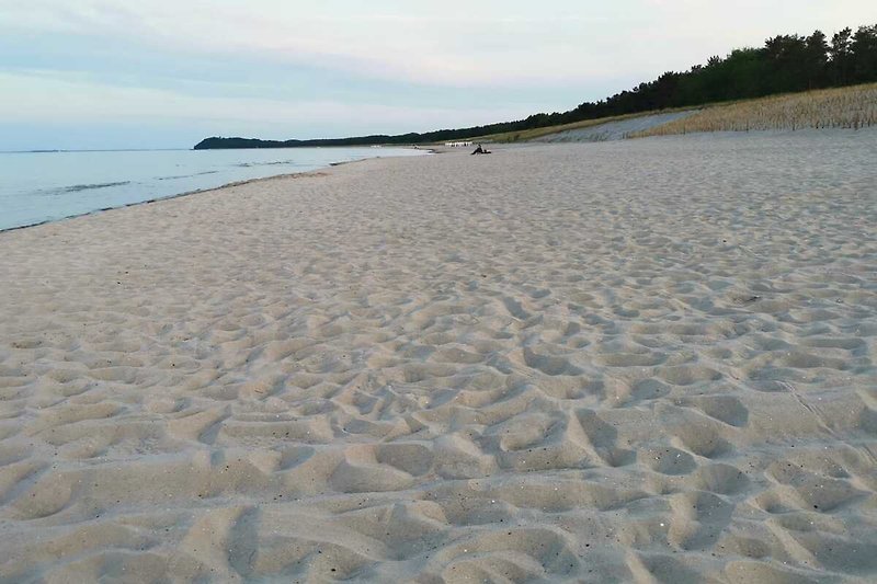 Entspannen Sie sich am ruhigen Strand mit azurblauem Wasser und malerischer Landschaft.