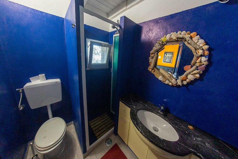 Una toilette blu e un bagno viola con arredamento elegante. Rilassati e goditi la tua vacanza!