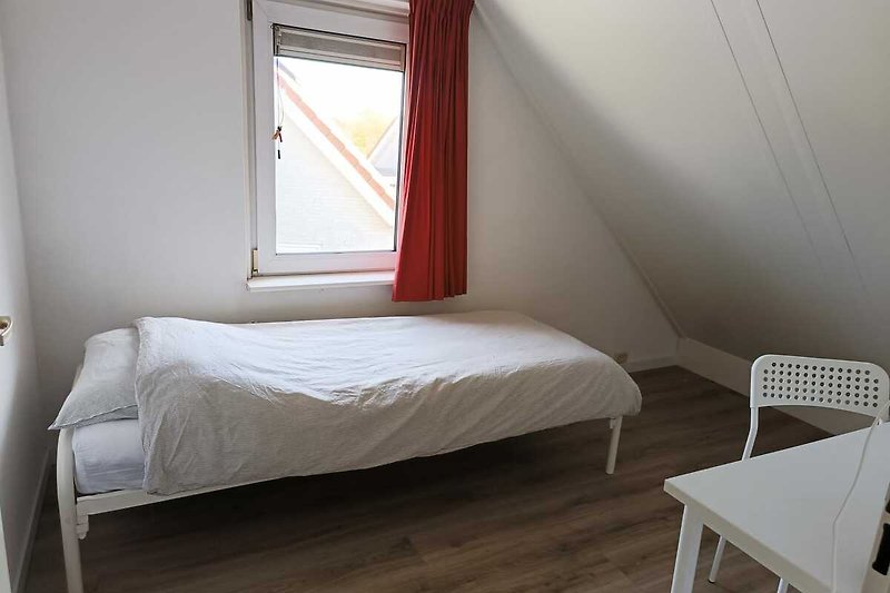 Willkommen in diesem komfortablen Schlafzimmer mit gemütlichem Bett und stilvollem Interieur. Entspannen Sie sich und genießen Sie die Aussicht aus dem Fenster.