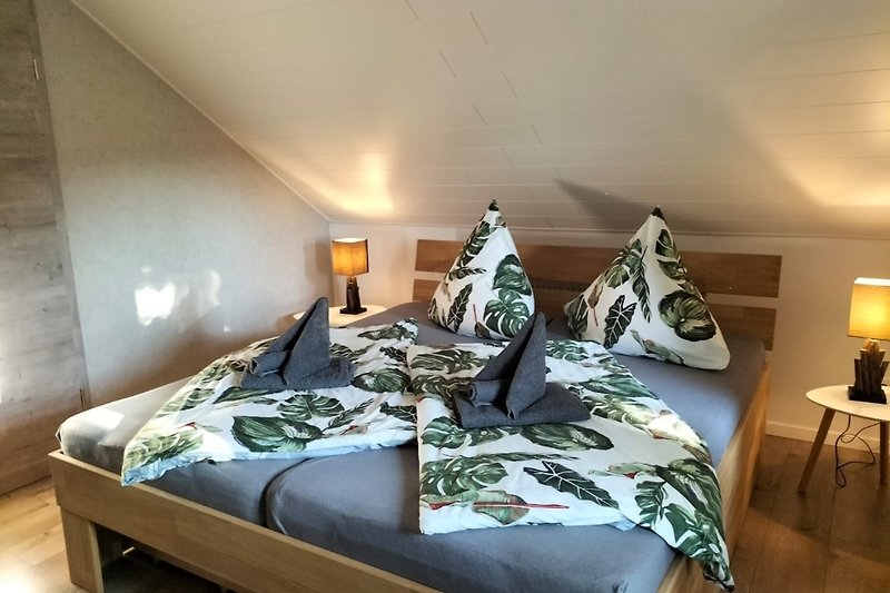 Gemütliches Schlafzimmer mit Holzbett, weichen Kissen und stilvoller Beleuchtung.