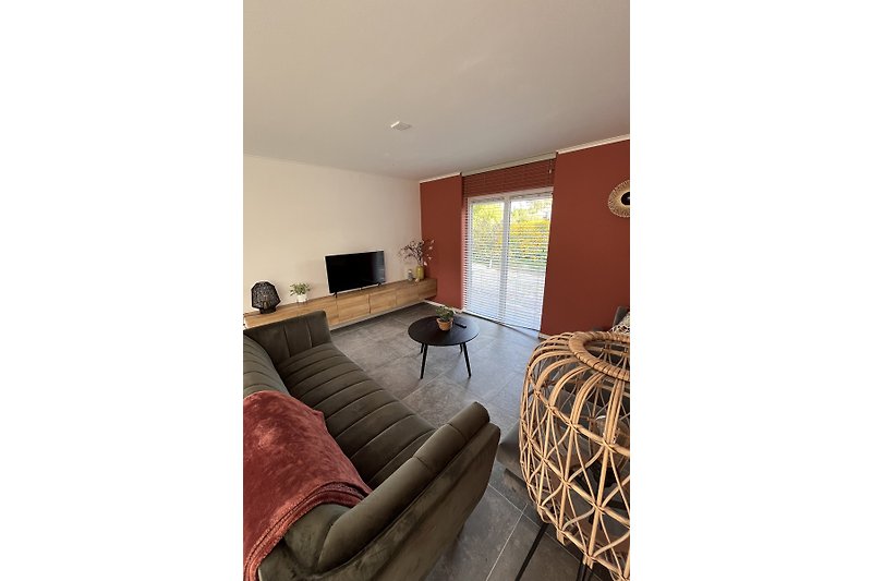 Een comfortabele woonkamer met houten vloer en gezellig meubilair.