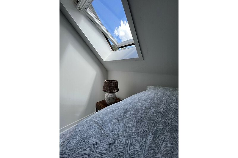 Een sfeervol interieur met comfortabel meubilair en een prachtig uitzicht op de azuurblauwe lucht.