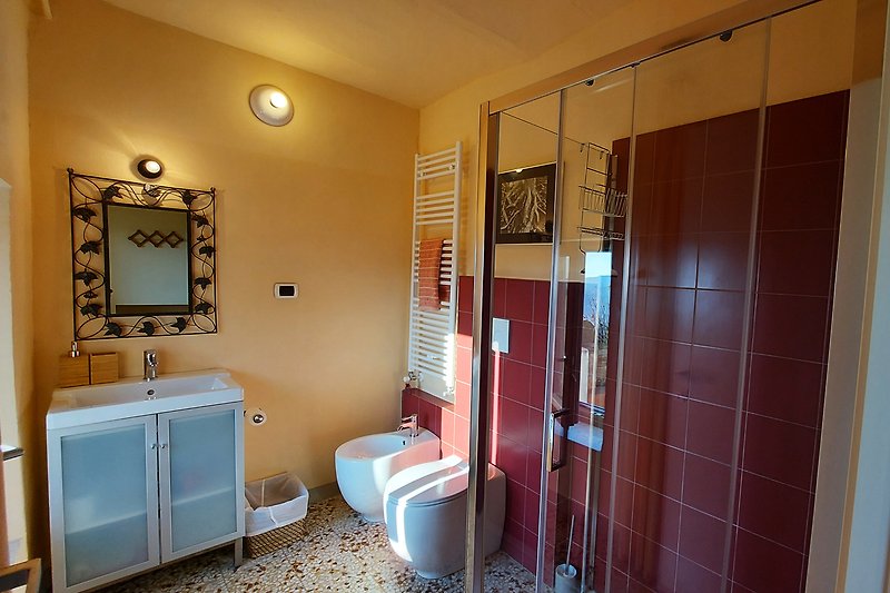 Questo bagno moderno e luminoso offre comfort e relax con il suo lavandino, armadietto e specchio.